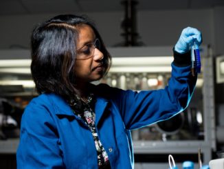 Une femme noire, manipulant un tube à essai dans un laboratoire