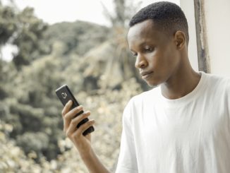 Un jeune africain tenant un smartphone en main.